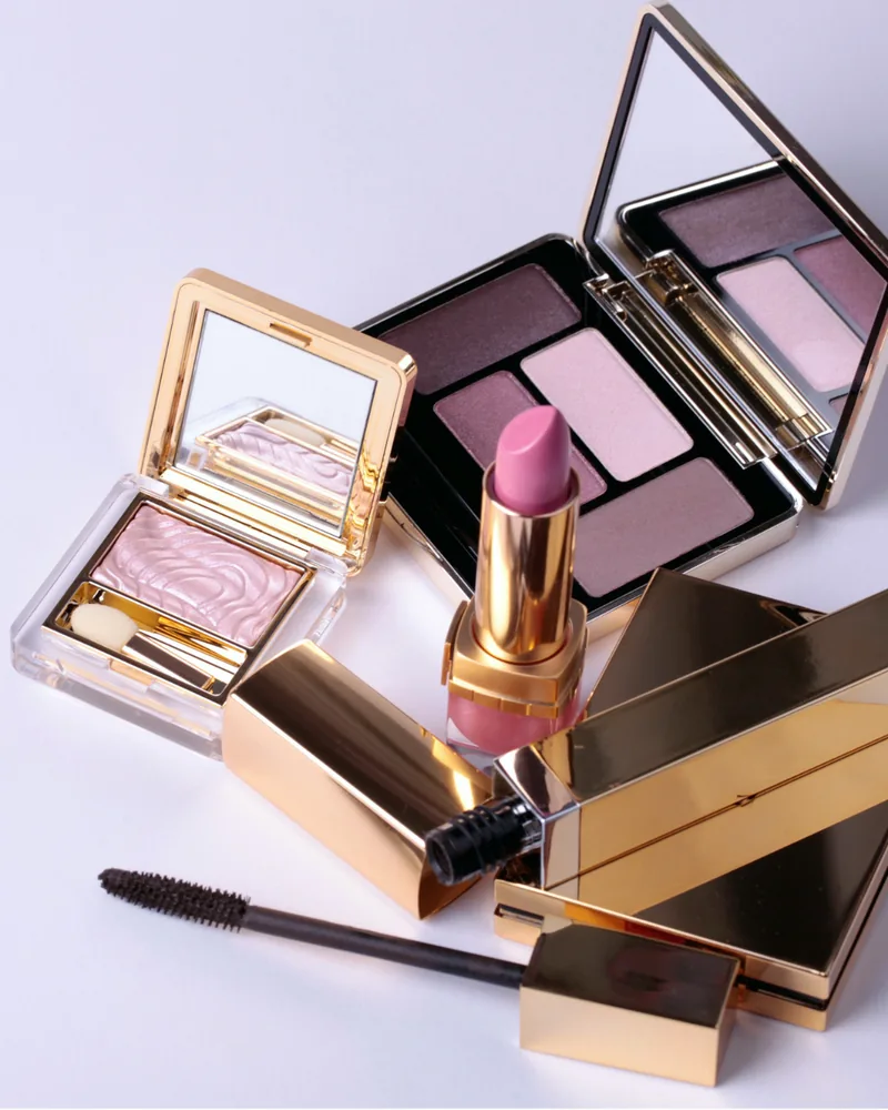 Make up Produkte als Flatlay in Gold- und Rosétönen